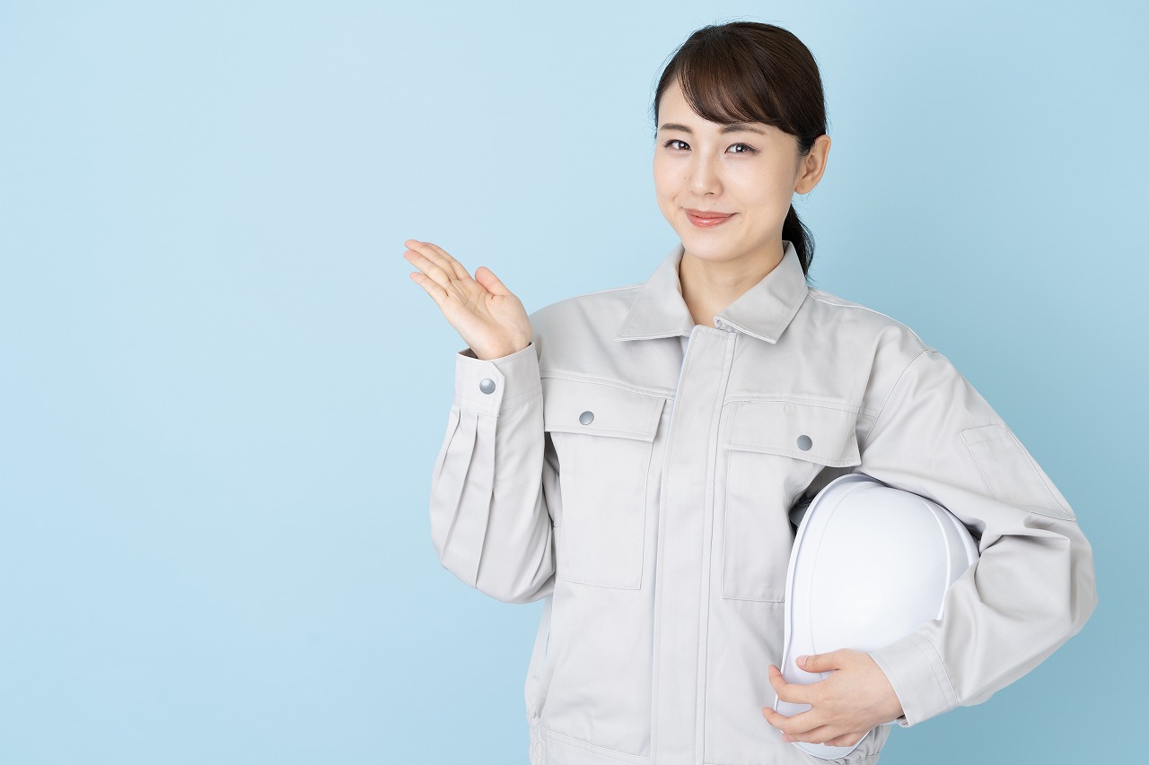 ヘルメットを抱える女性作業員